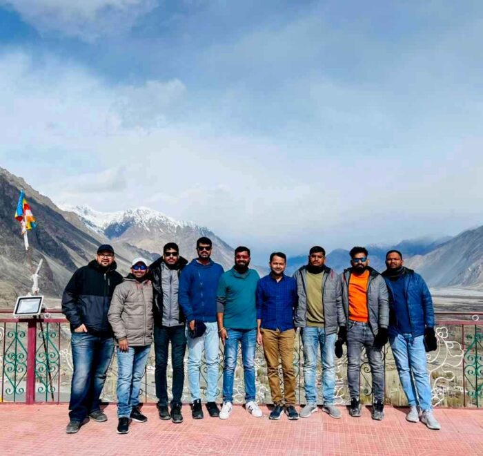 Group of riders posing at Diskit Monastery.
